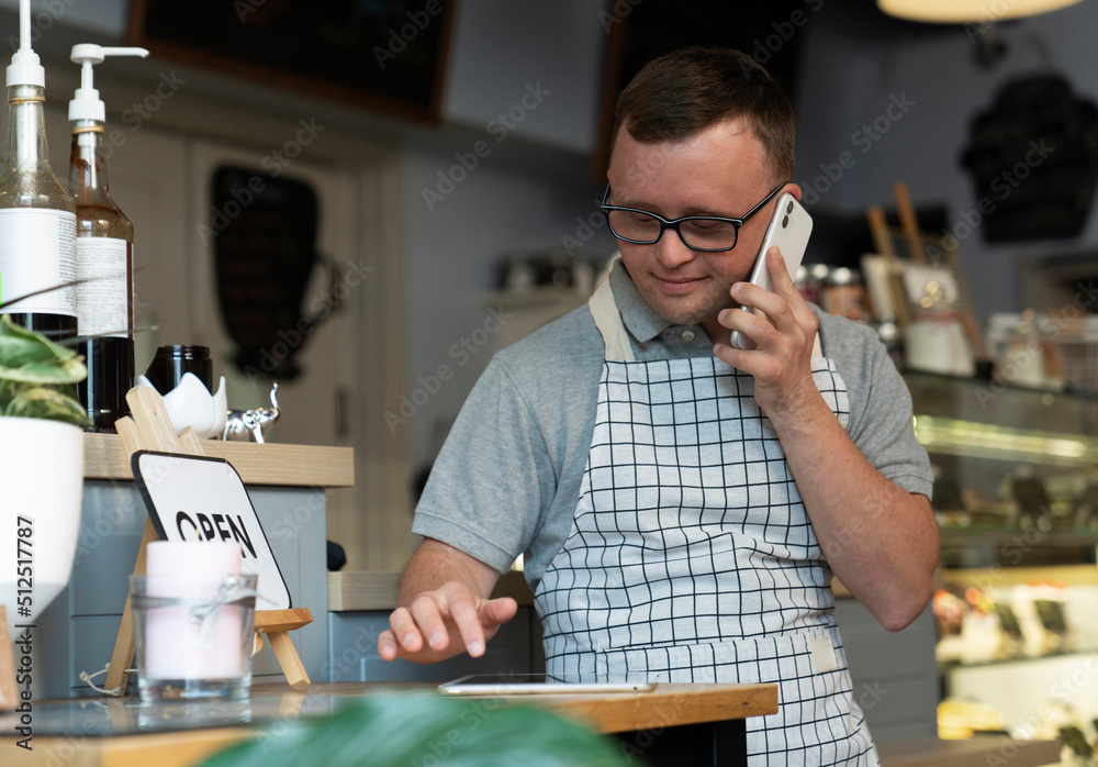 Owner of an independent restaurant taking a call at the front counter during service